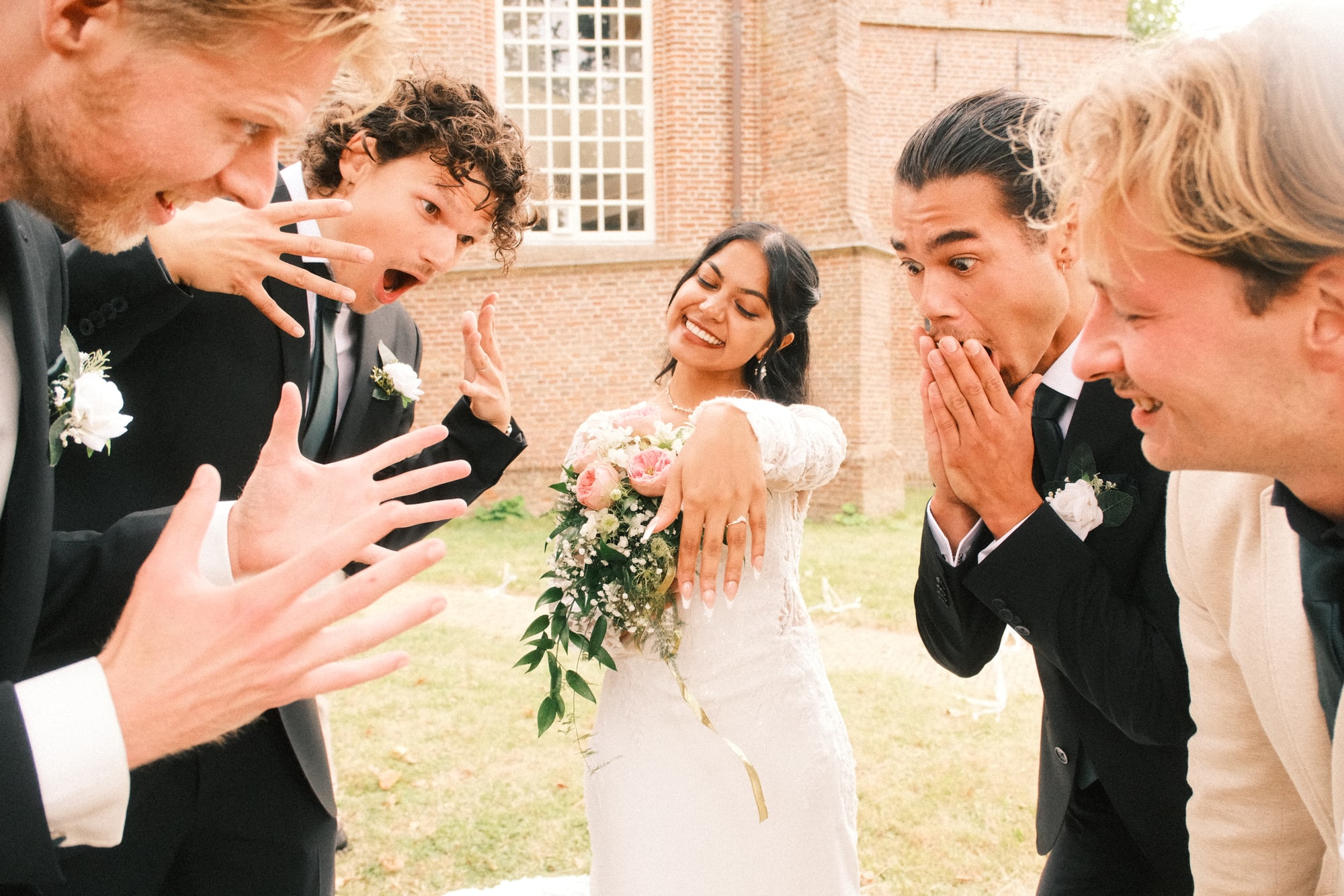 Vrienden reageren uitgelaten op de ring van de bruid