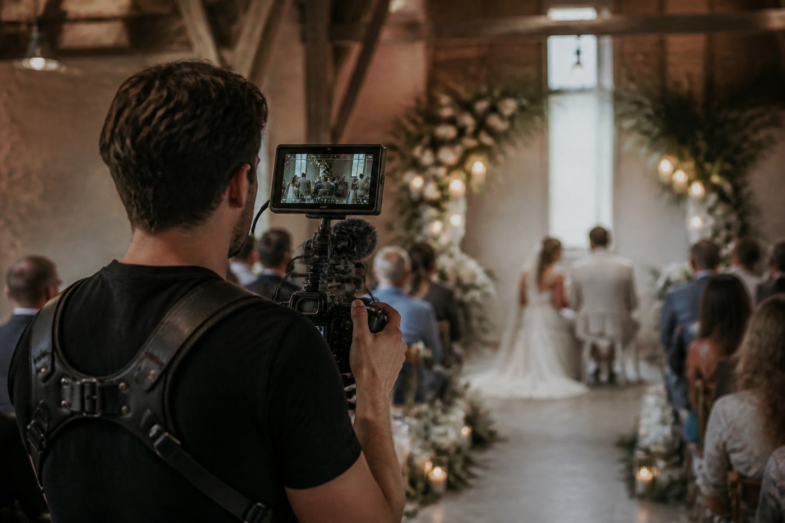 Een videograaf filmt de ceremonie vanuit het gangpad