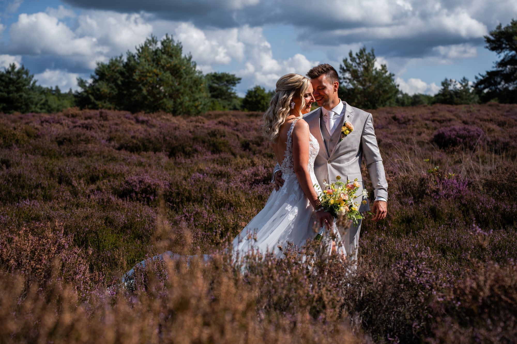 Het bruidspaar op de heide, lachend in de zon